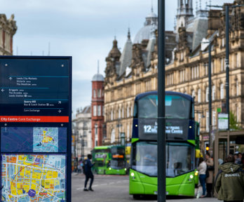 Sign with map and green bus in town centre