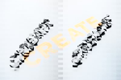 The word 'create' in wood on a white background